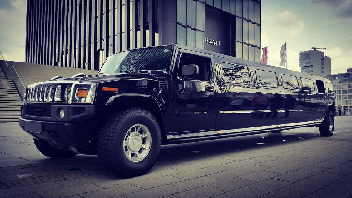 Schwarze Hummer H2 Stretchlimousine vor einem modernen Gebaeude