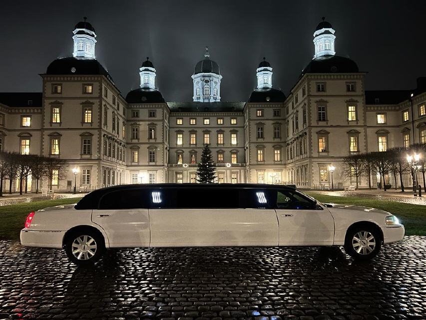 Lincoln Town Car Limousine vor einem beleuchteten Schlossgebaeude