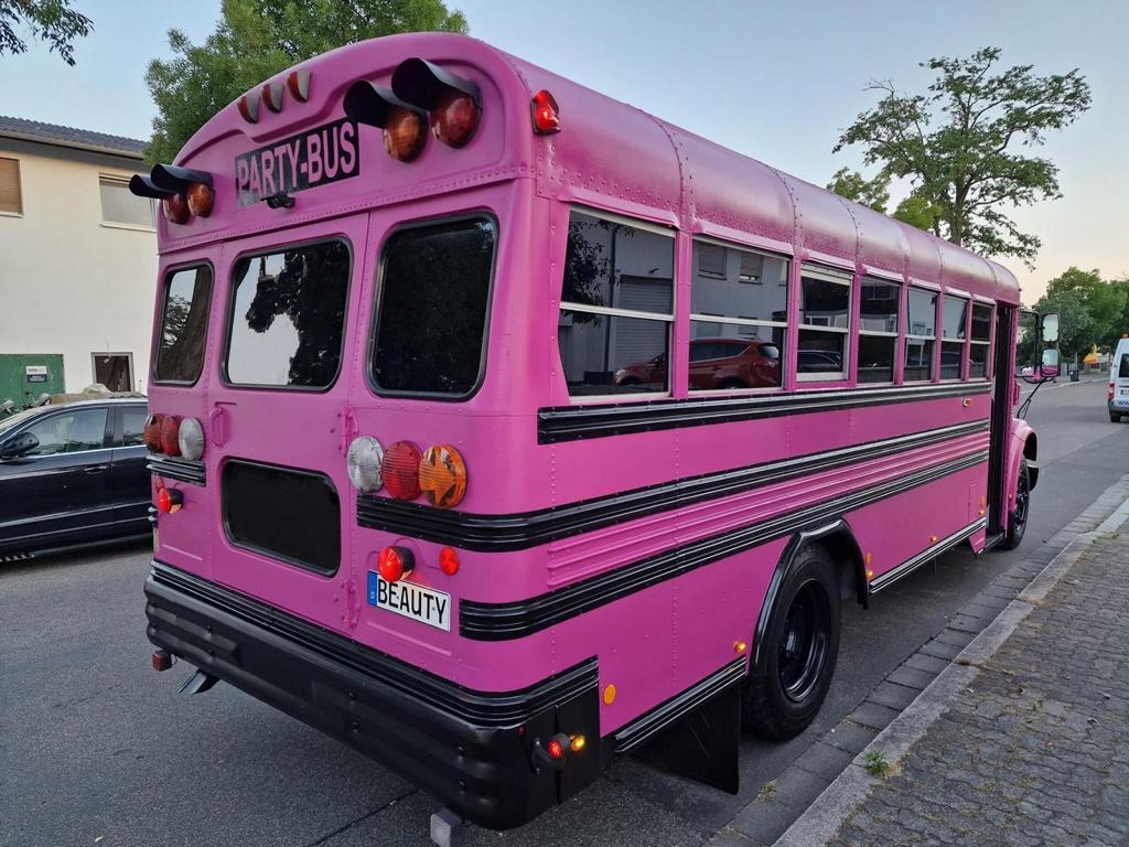 pinken Partybusses von hinten auf der Strasse