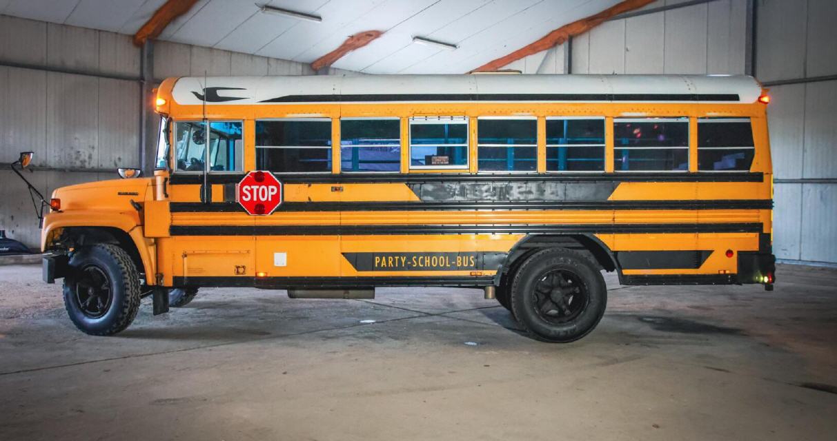 Gelber US-Schoolbus mit Stoppschild in einer Lagerhalle